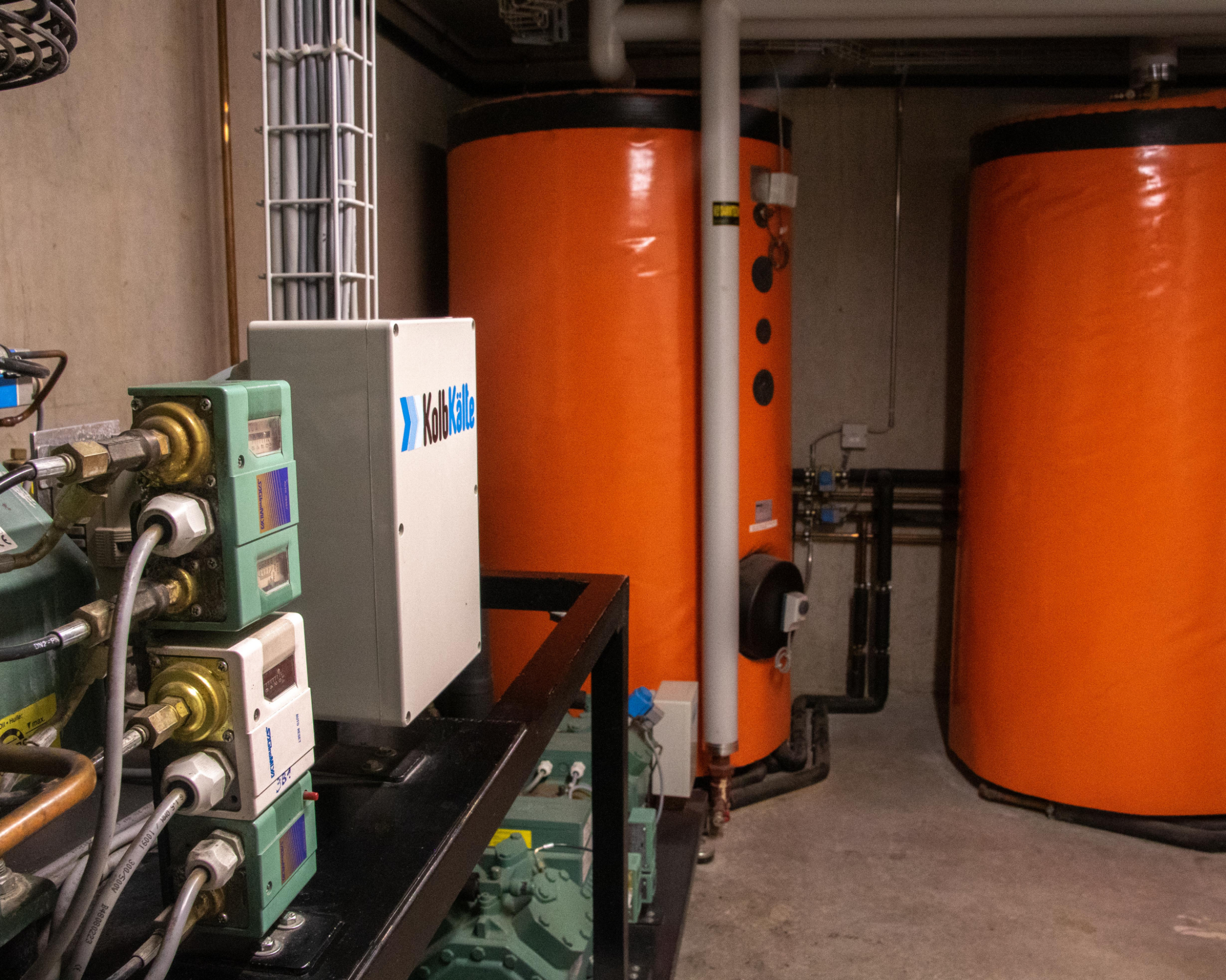 Technikraum mit Kompressor, der Abwärme der Kühlanlagen in die dahinterstehenden Boiler leitet, um das darin enthaltene Wasser zu erwärmen.