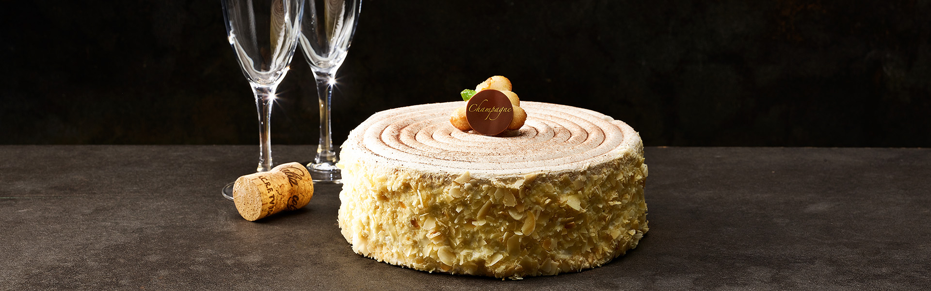 Eine Champagnerrahm Torte ist mit zwei Sektgläsern präsentiert.