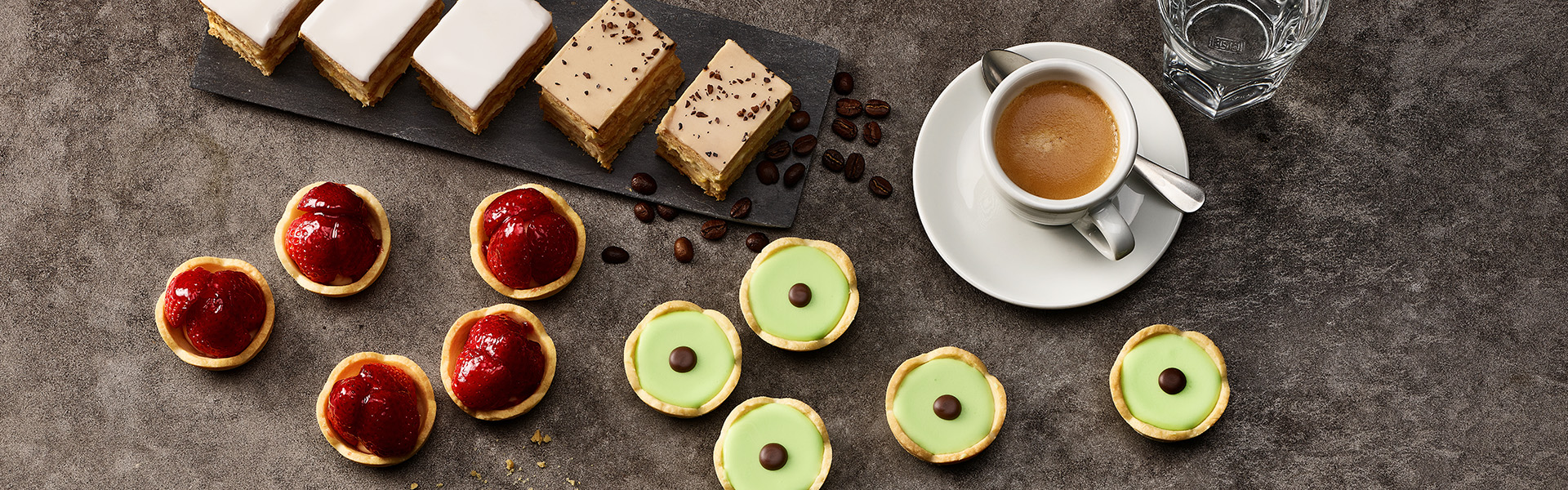 Diverse kleine Patisserie mit einem Kaffee angerichtet.