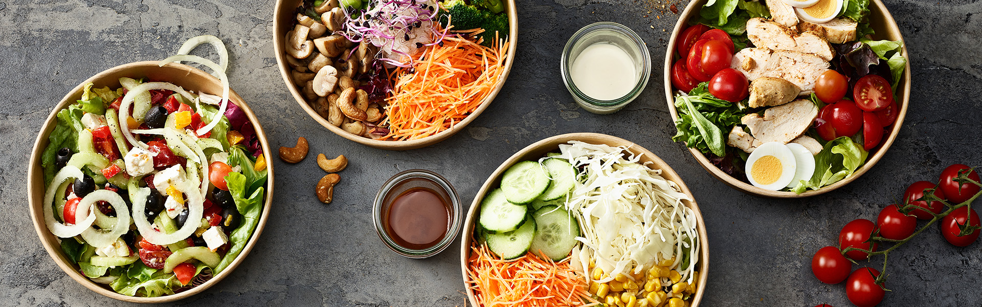 Vier verschiedene Salate sind in Bowls angerichtet.