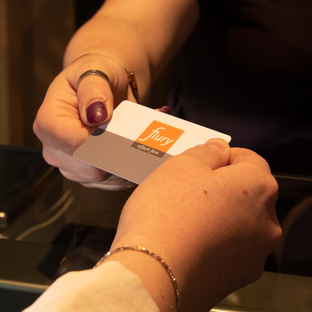 Kundin bezahlt mit Kundenkarte. Kundin übergibt Kundenkarte an Mitarbeiterin.
