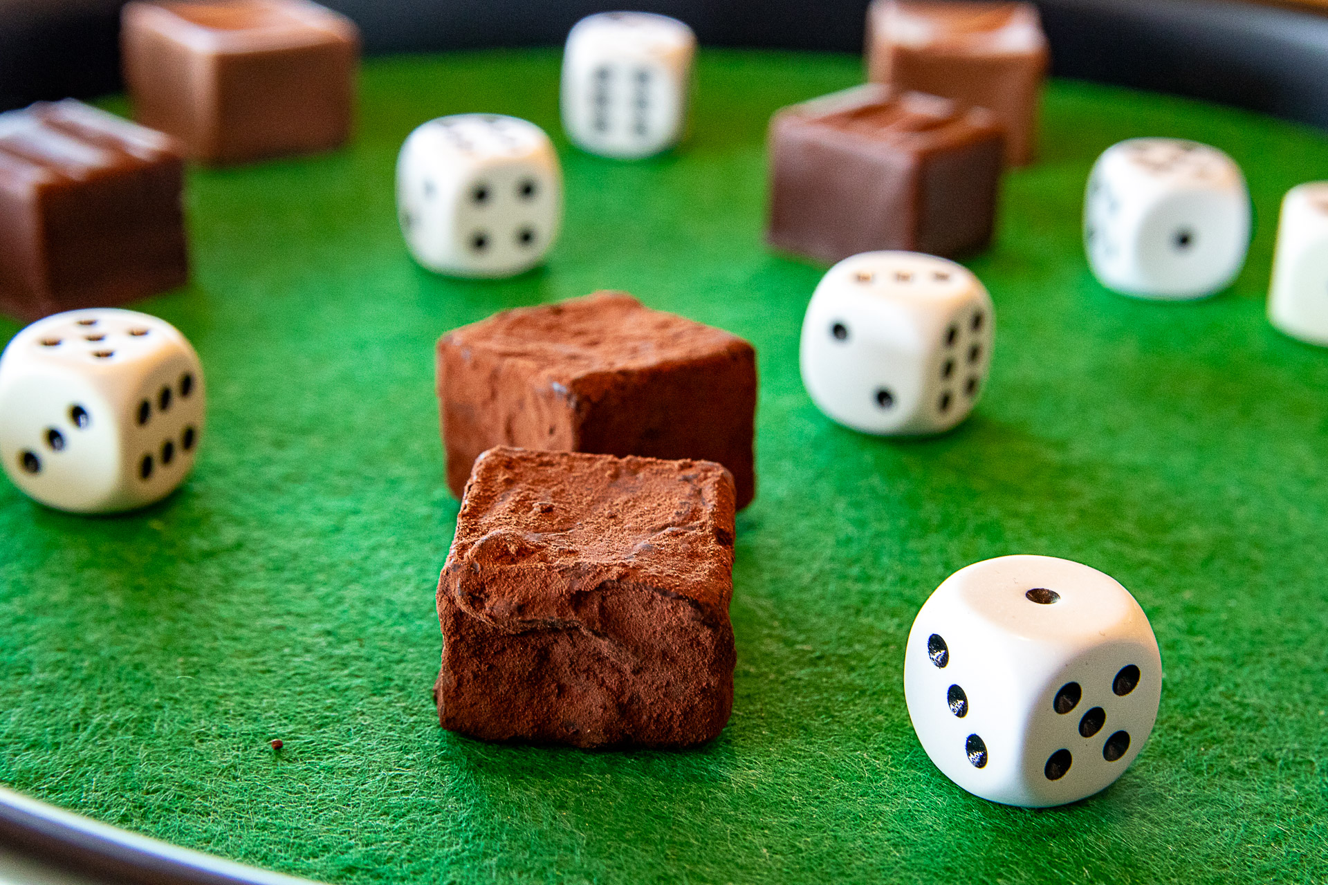 Truffe Würfel und Spielwürfel liegen auf einem Würfelbrett verteilt.