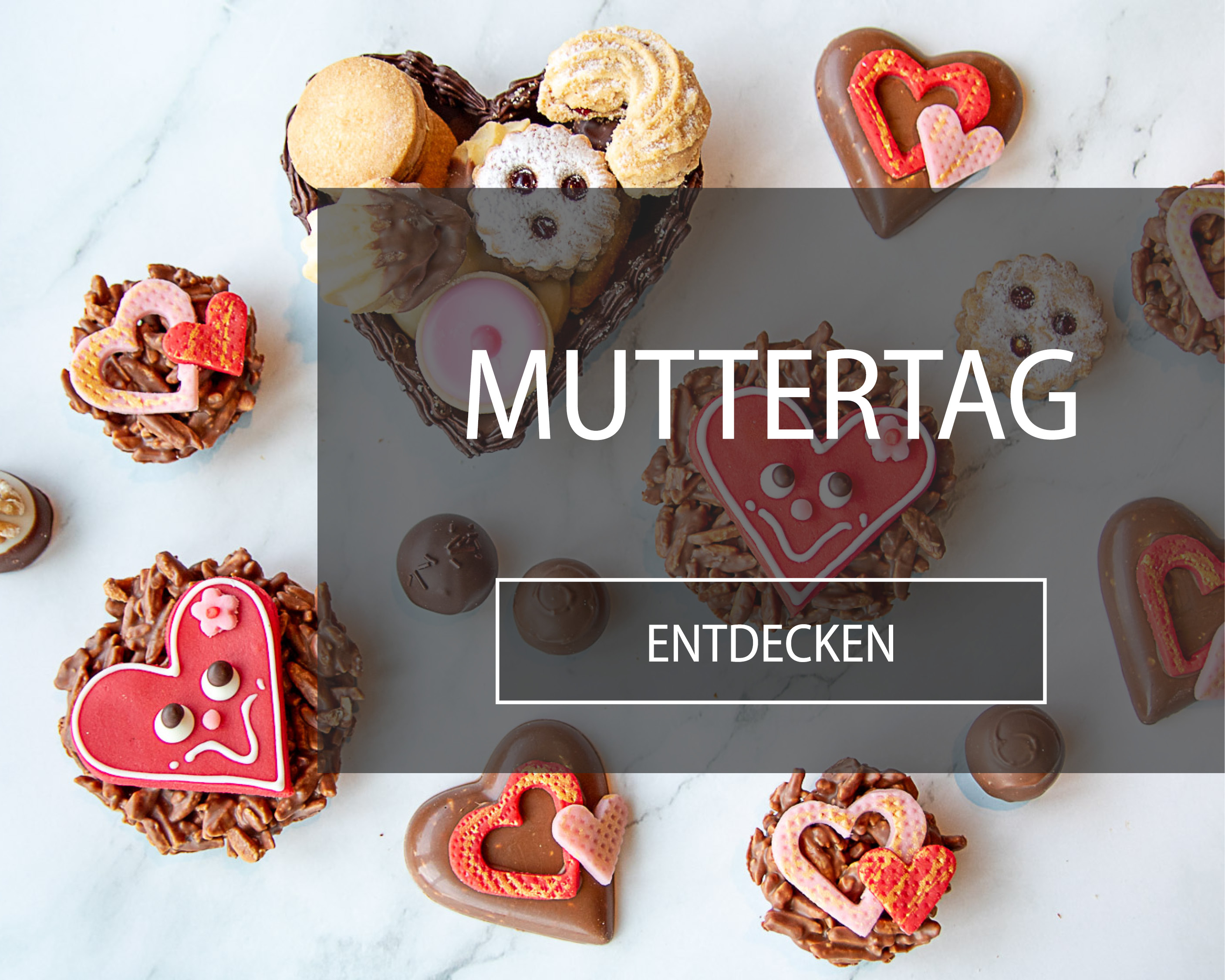 Diverse handgemachte Muttertagsgeschenke aus feinster Schweizer Schokolade mit Marzipanherzen garniert.