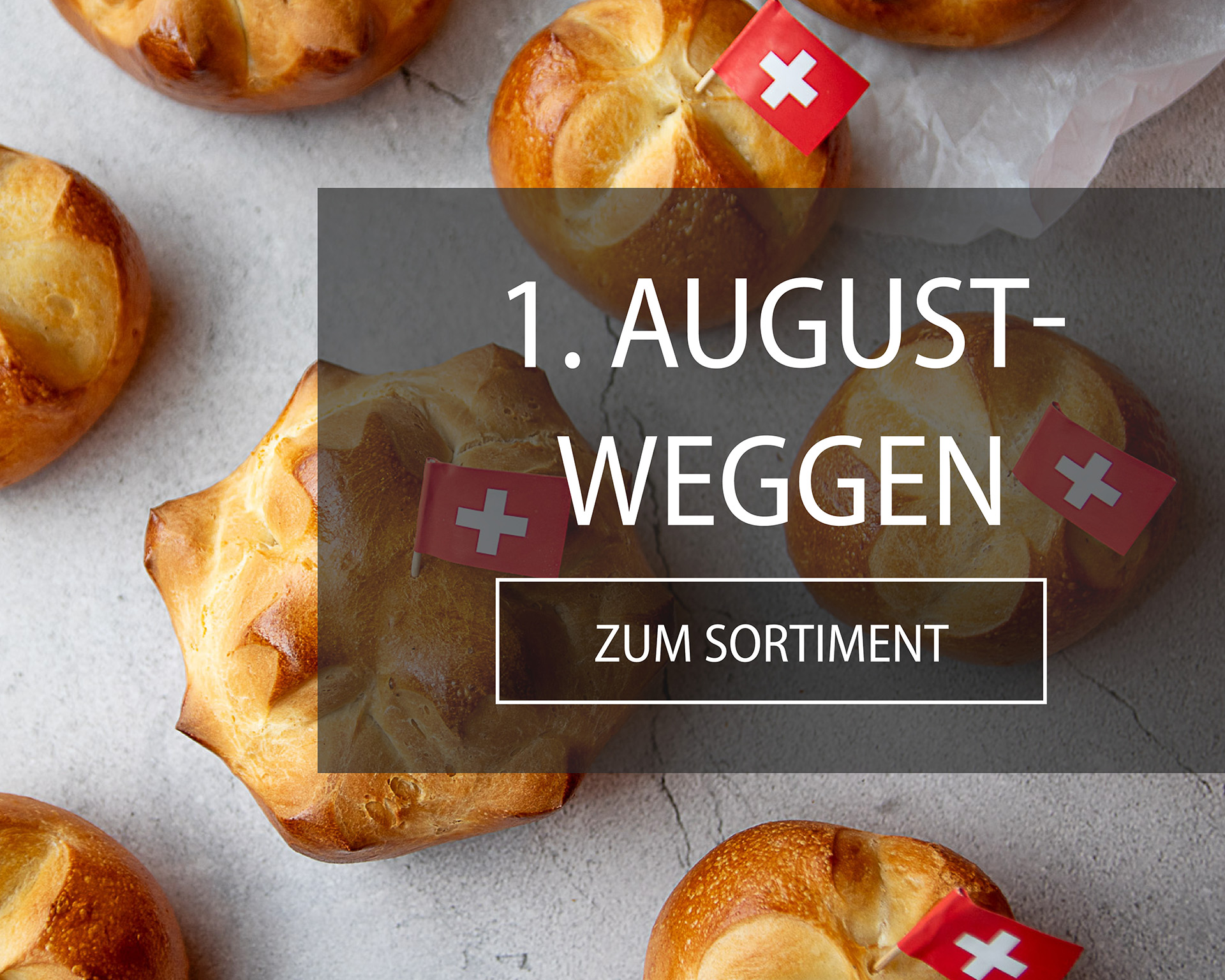 1. August-Weggen mit typischem Schweizerkreuz und Schweizerfähnli auf einer Betonplatte verteilt.