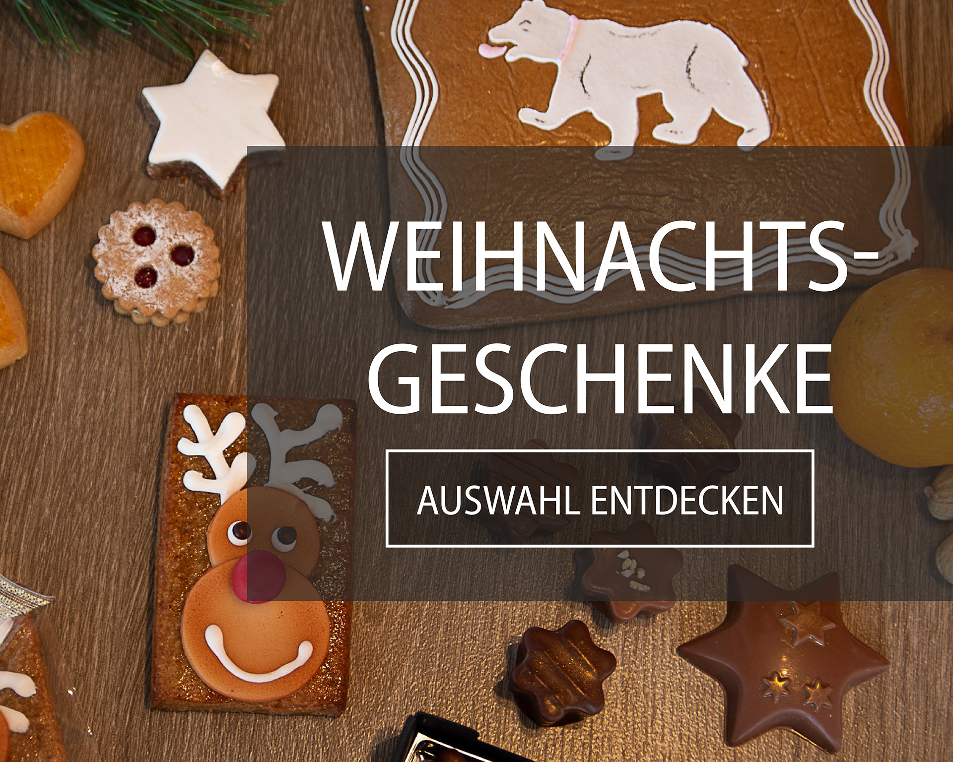 Weihnachtskonfekt und Lebkuchen liegen auf einem festlichen Tisch verteilt.