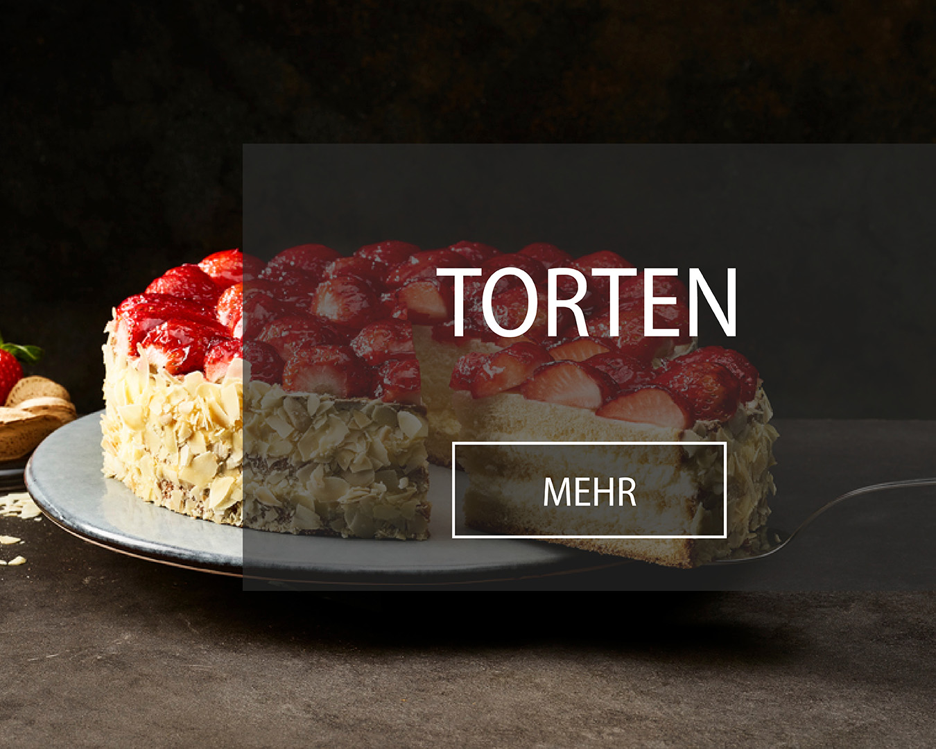Fruchtorte garniert mit frischen Erdbeeren, ummantelt von Mandelsplittern wird angeschnitten.