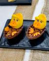 Aus Marzipan modellierte Enten in einer Schokolanden-Ei Hälfte.