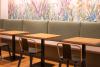 gemütliches und modernes Café in Subingen mit Polster-Bank und floraler Tapete.