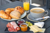 Frühstücksplättli mit Käse und Fleisch, Kaffee und ein Teller mit Gipfeli und Weggli.